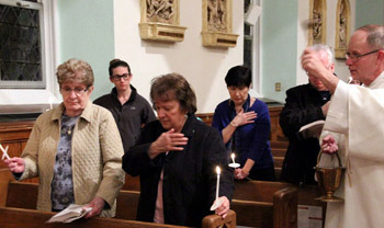 deacon blessing the renewal of baptismal promises by some elderly women